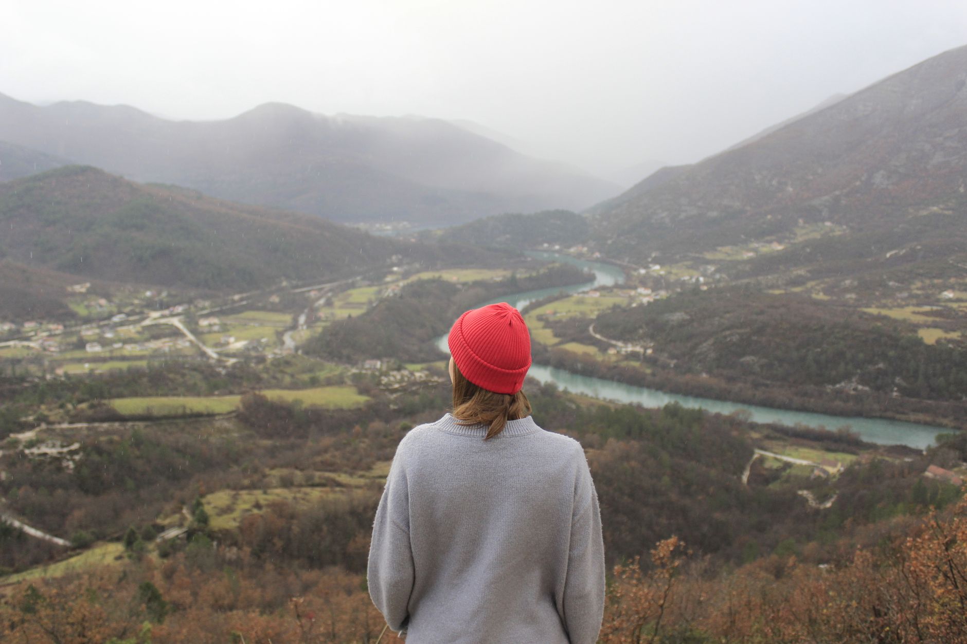 Travel writer reviewing notes overlooking a peaceful mountain valley